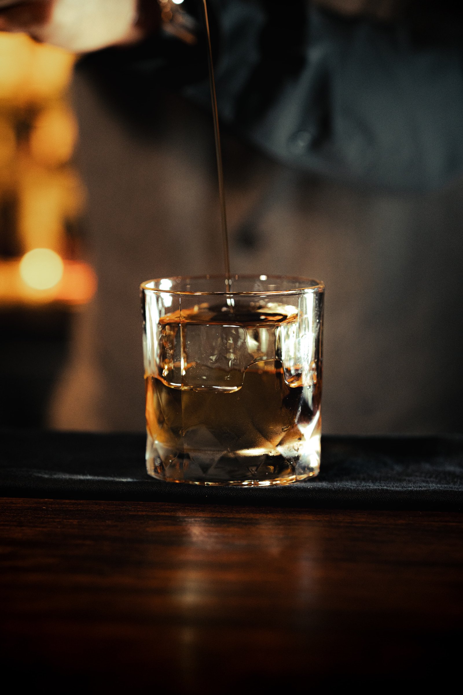 Whiskey being poured over a KORI ice cube
